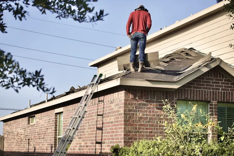 Professional roofer working on a residential roof in Baker